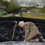 a-war-veteran-from-russia-kneels-in-front-of-a-tank-that-he-spent-the-war-in-the-tank-is-now-a-museum