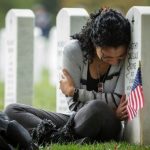 a-widow-leans-on-her-husbands-headstone-on-the-day-before-their-wedding-anniversary-on-16th-october-2013