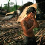 a-young-man-holds-his-face-in-the-rain-in-the-city-of-rangoon-cyclone-nargis-hit-myanmar-leaving-millions-homeless-and-over-10000-dead-in-may-2008