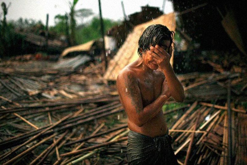 a-young-man-holds-his-face-in-the-rain-in-the-city-of-rangoon-cyclone-nargis-hit-myanmar-leaving-millions-homeless-and-over-10000-dead-in-may-2008