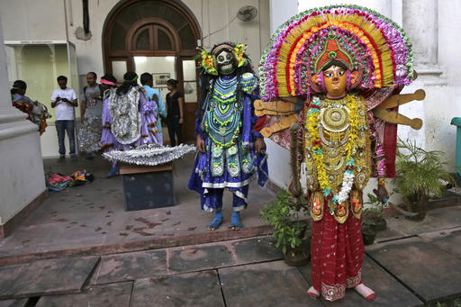 India's traditional Chhau dancers dressed as Hindu goddess Durga, right and a demon, second right, wait backstage for their performance to mark World Tourism Day at the Indian Museum in Kolkata, India, Tuesday, Sept. 27, 2016. The museum opened a gallery for masks on Tuesday. (AP Photo/Bikas Das)