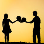 A man and a woman holding a broken heart